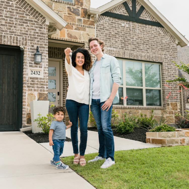 Family standing in front of their finished new home